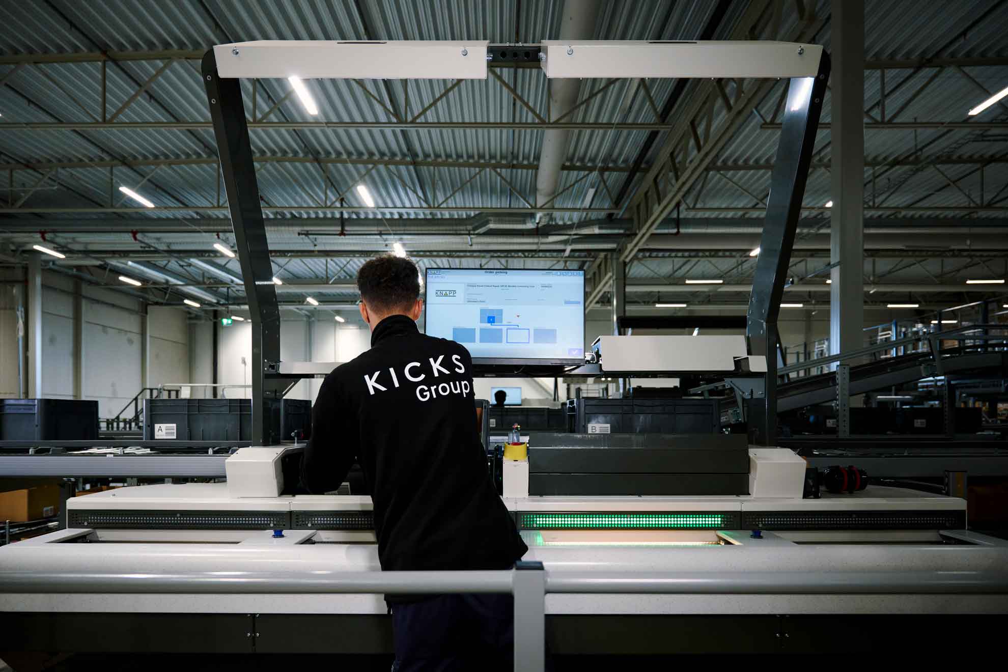 Lagerarbetare vid ergonomisk plockstation